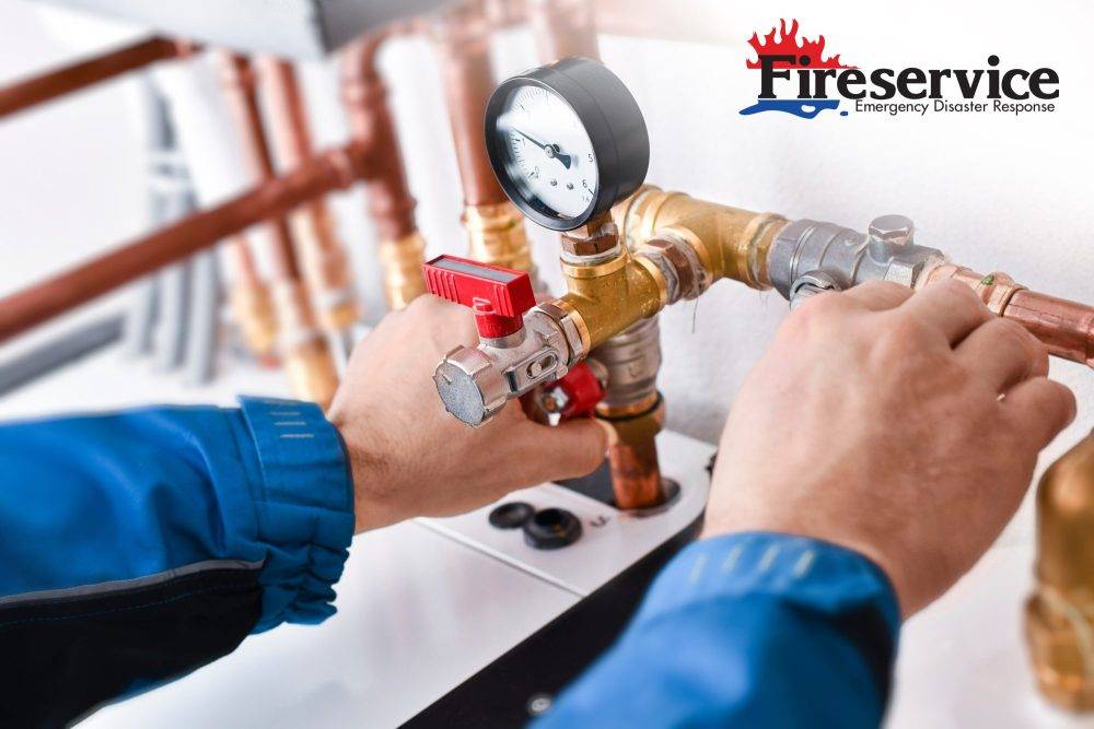 A technician checking the pressure gauge on a heating system.