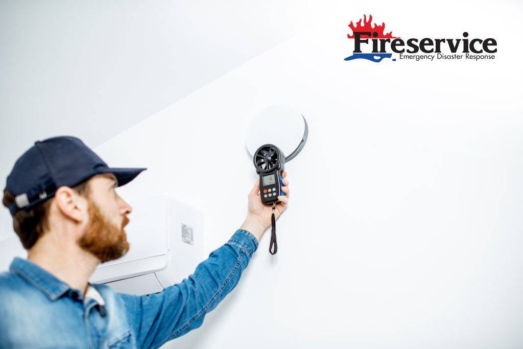 A mold inspector scanning a wall for signs of mold growth. 