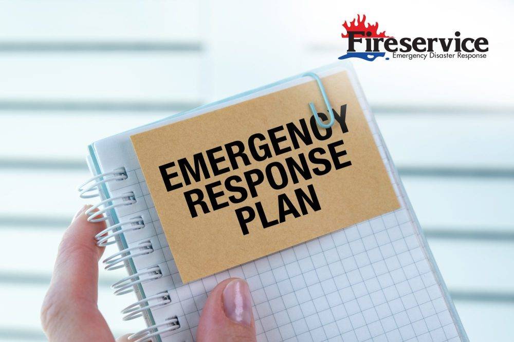 Close-up of a hand holding a notebook labeled Emergency Response Plan.