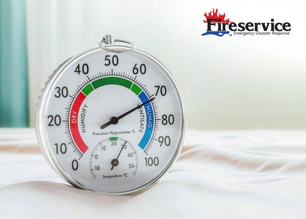 Hygrometer in bedroom showing high humidity. Gauge needle is in "HUMID" zone. Humidity control of air quality, home comfort, and indoor climate.