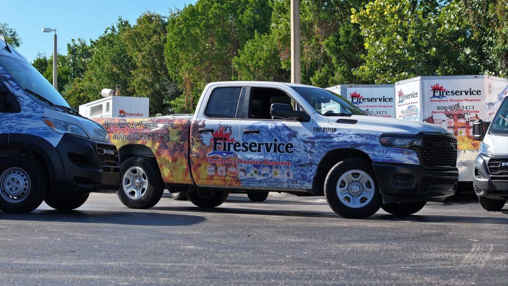 A Fireservice truck in a parking lot surrounded by other company vehicles.
